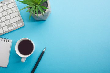 Blue desk office with laptop, smartphone and other work supplies with cup of coffee. Top view with copy space for input the text. Designer workspace on desk table essential elements on flat lay