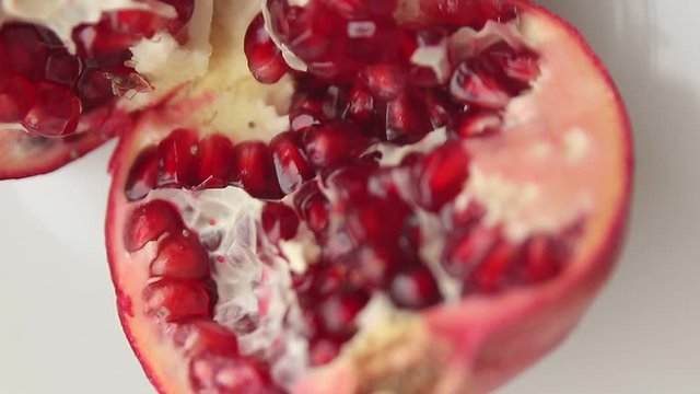 sliced pomegranate fruit in a white plate with camera rotation