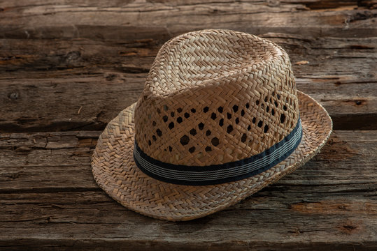  A straw hat is on an old wooden background.