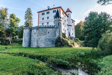 Fototapeta na wymiar Famous 13th century Sneznik Castle (Grad Snežnik, Schloß Schneeberg), Slovenia. State castle Sneznik reflecting in a beautiful pond. Loška Dolina, Slovenia.