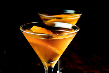 Mixed cocktail in two martini glasses with black background