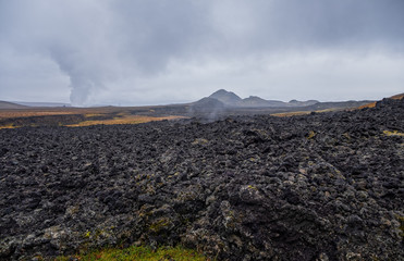 Leirhnjukur old black lava field and smoke in Iceland, overcast. Cloudy day in September 2019