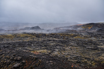 Leirhnjukur old black lava field and smoke in Iceland, overcast. Cloudy day in September 2019