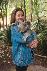 Magnetic island, Australia: Young happy woman holding koala and smiling	
