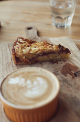 Hot cup cappuccino coffee with apple pai on the rustic wooden desk