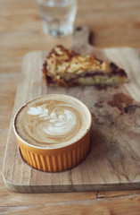 Hot cup cappuccino coffee with apple pai on the rustic wooden desk