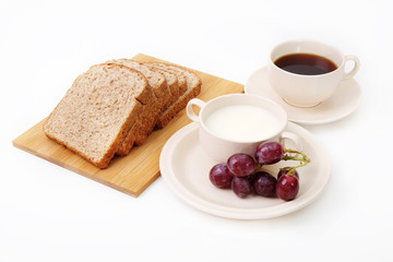 Whole grain bread, grapes and milk serve with a cup of coffee..