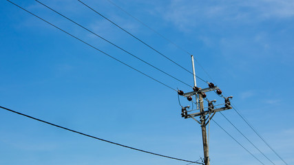Electric poles against a cloudy blue sky background. Spring has come