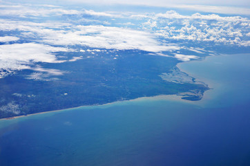 Blue sea with clouds with beach view, an aerial shot from airplane.