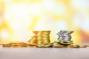 Coins on table / Pile of Golden coin, silver coin and copper coin on light over bokeh background money financial