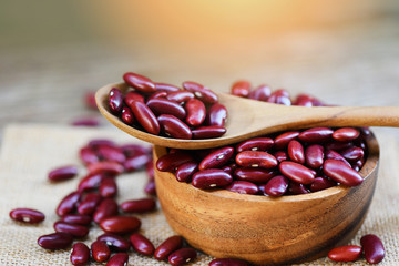 Red bean in wooden bowl and spoon on sack background - Grains red kidney beans
