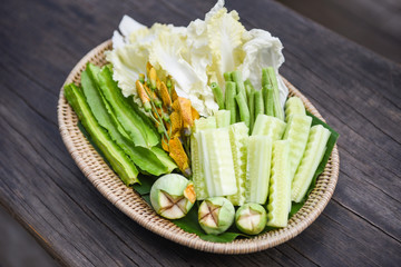 Obraz na płótnie Canvas Thai vegetable basket - Set of green vegetable local with Cucumber Eggplant Chinese cabbage Sesbania Grandiflora Winged Bean and Yard long bean
