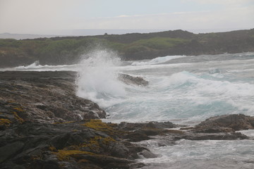 waves crashing on lava rocks