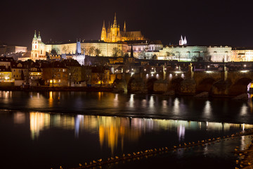 Fototapeta na wymiar Night winter Prague Lesser Town with the gothic Castle and Charles Bridge above the River Vltava, Czech Republic