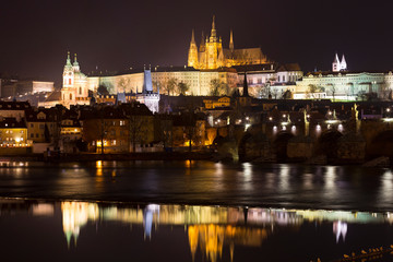 Fototapeta na wymiar Night winter Prague Lesser Town with the gothic Castle and Charles Bridge above the River Vltava, Czech Republic