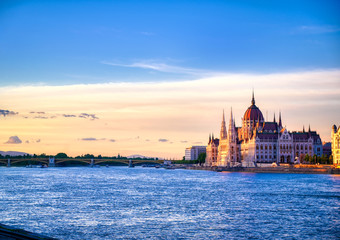 Obraz premium Budynek parlamentu węgierskiego położony nad Dunajem w Budapeszcie na Węgrzech o zachodzie słońca.