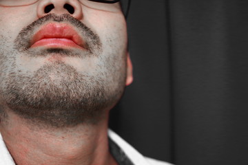 Obraz premium 無精髭を生やしたハンサムな学生のセクシーな唇