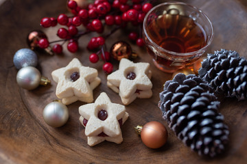 Christmas shortbread star cookies with strawberry jam. Festive atmosphere holiday pastry baking concept. Cookies and tea for Santa