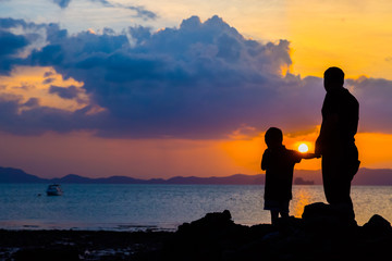 Fototapeta na wymiar Silhouette image of father and son at the beach