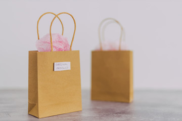 original product vs dupe imitation, shopping bags with labels side by side with similar paper color