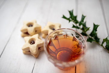 Christmas shortbread star cookies with strawberry jam. Festive atmosphere holiday pastry baking concept. Cookies and tea for Santa