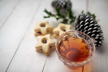 Christmas shortbread star cookies with strawberry jam. Festive atmosphere holiday pastry baking concept. Cookies and tea for Santa