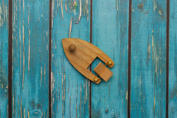 wooden toy boat on a blue wooden background