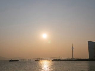 Fototapeta na wymiar Sunset view of the building, tower, Kun Iam Statue, Macau Taipa Bridge