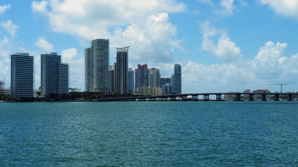 Fototapeta premium South beach skyline, Florida, multiple buildings on the horizon next to the sea, bridge crossing over water