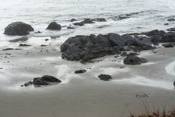 Waves rolling on beach over sand .