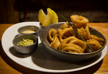Mediterranean flavors. Fried squid rings with lemon and sauce