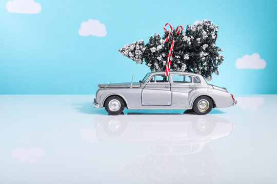 Tiny toy Christmas tree tied onto a vintage toy car