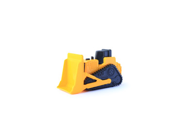 Fototapeta premium The yellow toy car Bulldozer isolated on white background. Children's tractor toy. Wheel loader construction car model.