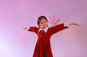 Portrait of happy little girl poses hands open wide against christmas background in the winter season and happy new year festival.