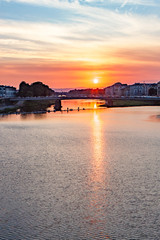 Naklejka premium Vertical Crop Fiery Red Sun Setting on the Arno River in Florence