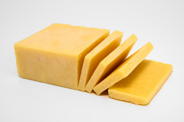 Cheddar cheese brick with slices isolated on white background.