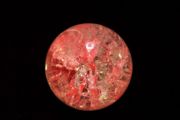 Glowing crystal ball with cracks inside on a dark background. The process of predicting the future