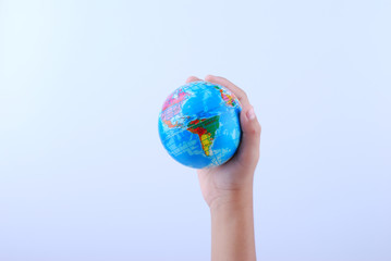 Hand holding earth globe on white background