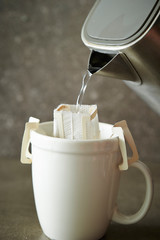 Hand drip coffee in white mug cup 