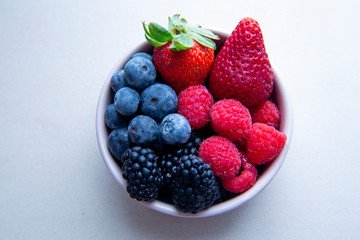strawberries, blueberries, blackberries and raspberries in the bowl