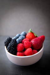 strawberries, blueberries, blackberries and raspberries in the bowl
