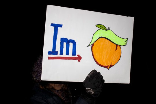 12-17-2019 Tulsa USA Woman at night political rally holds up graphic sign for impeachment
