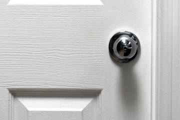 Silver Door Knob on white door , stainless steel round ball metallic door knob.