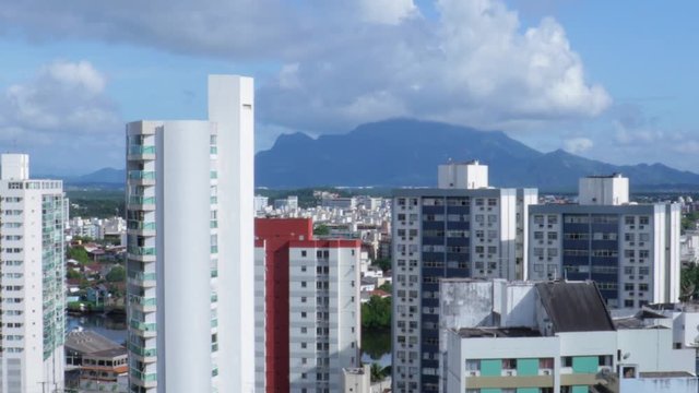 Time lapse over the skyline buildings with the Mestre Alvaro mountain on the back ground. On a sunny day a lot of clouds moving fast. Vitória, Espírito Santo, Brazil.