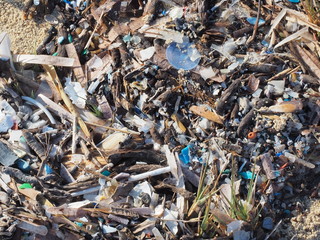 Environmental pollution. Sand beaches polluted with pieces of plastic waste. Micro plastics debris on the beach. Pieces of plastic residues