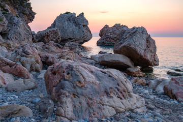 large stones with beautiful texture on the background of dawn on the sea