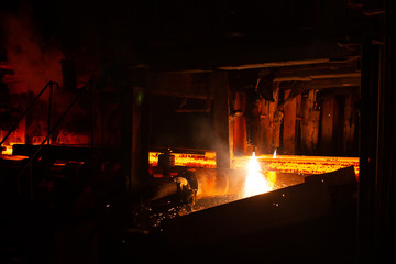 Fototapeta na wymiar Hot red steel billets at torch cutting. Background of the blacksmith and metallurgical industry.