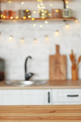 wooden table and blurry kitchen interior in the background. Preparation for design.