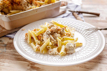 Italian Pasta Penne with chicken meat, smoked cheese and spices. Traditional Italian cuisine. Mediterranean food. Close up