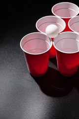 Beer pong college game on black background